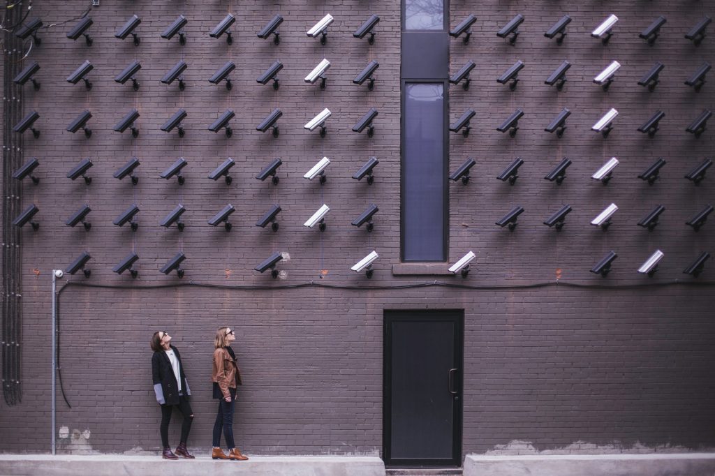 two person standing under lot of bullet cctv camera